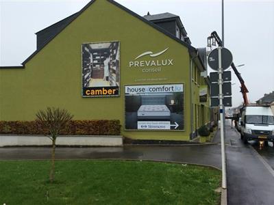Das Matratzengeschäft House of Comfort in Strassen, Giebel mit Werbeplakat.