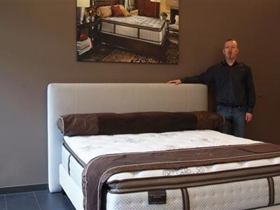 Nico Dhur, owner of House of Comfort, next to a luxurious bed